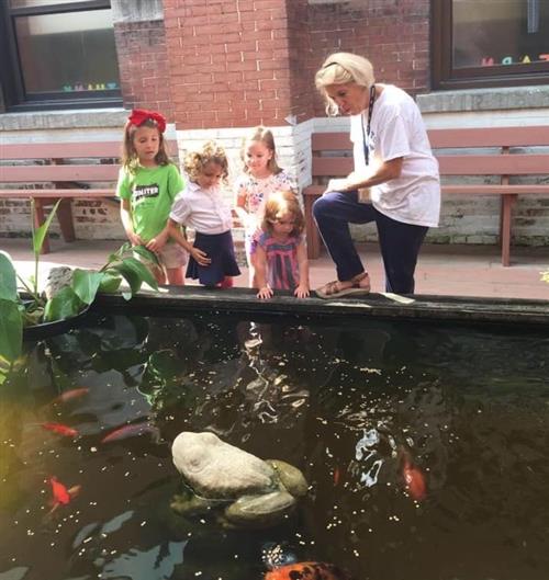 Ms. Phillips with students next to the pond 