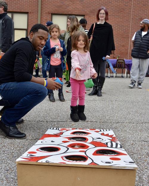Mr Humphrey assists a future student at a carnival game 