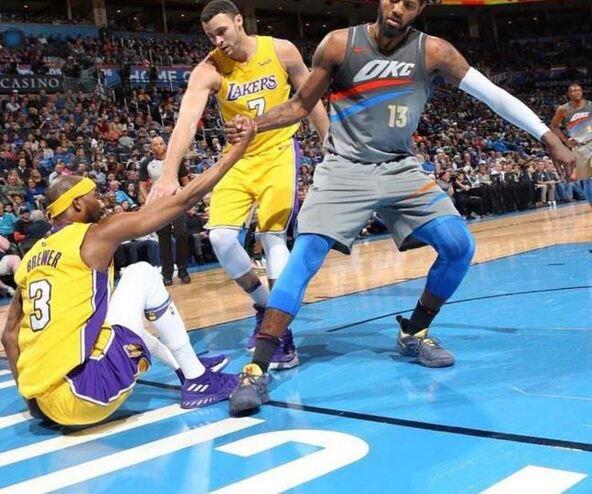 NBA players helps another player off the court.